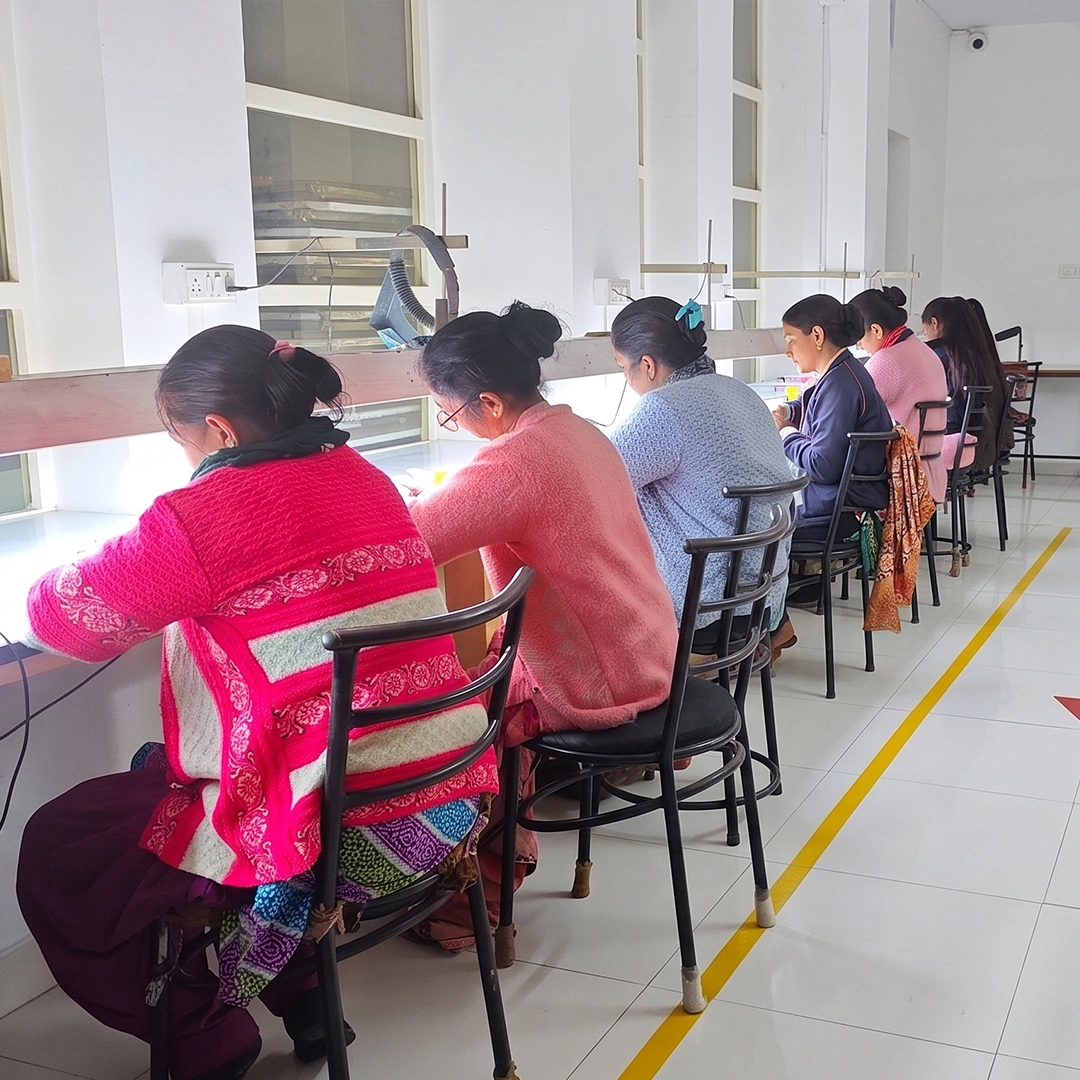 Female artisans working at a jewelry manufacturing bench
